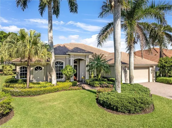 a view of a house with a yard and palm trees