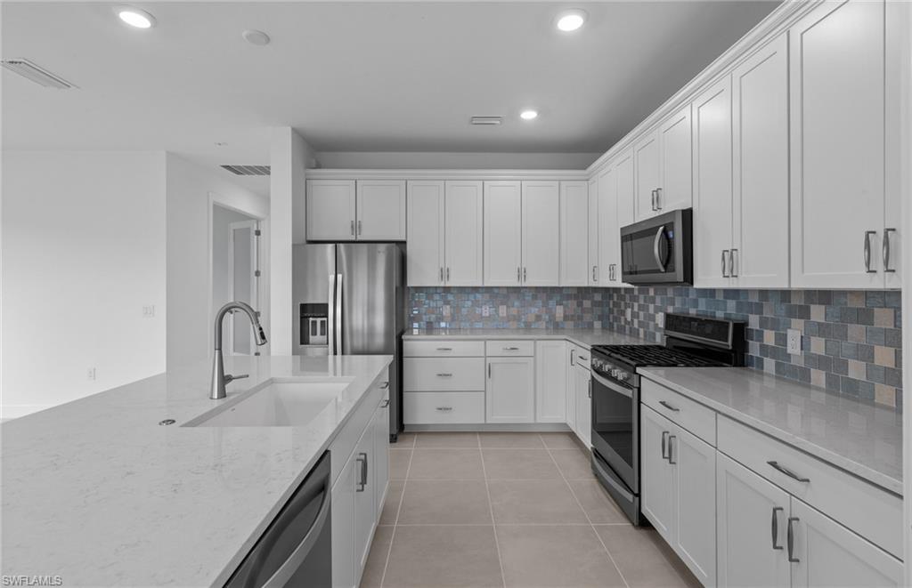 42544 Adirondack Drive Punta Gorda, FL 33982 - Photo 12 of 29 a kitchen with stainless steel appliances granite countertop a sink stove and refrigerator