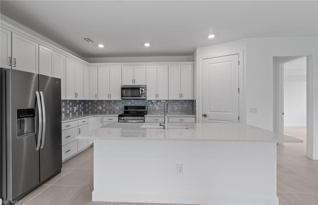 42544 Adirondack Drive Punta Gorda, FL 33982 - Photo 15 of 29 a kitchen with stainless steel appliances a refrigerator and a stove top oven