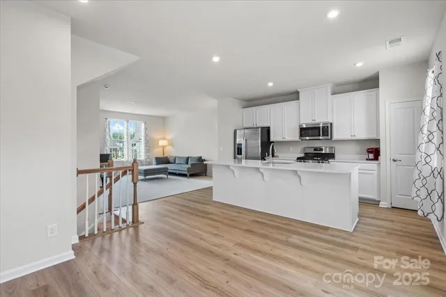 a view of kitchen with microwave a refrigerator and cabinets