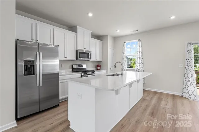 a kitchen with kitchen island a sink stainless steel appliances and window