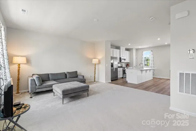 a living room with furniture and kitchen view