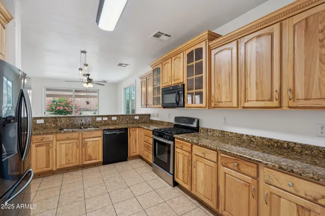a large kitchen with stainless steel appliances granite countertop a stove a sink dishwasher and a refrigerator