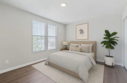 a bedroom with a large bed and a potted plant