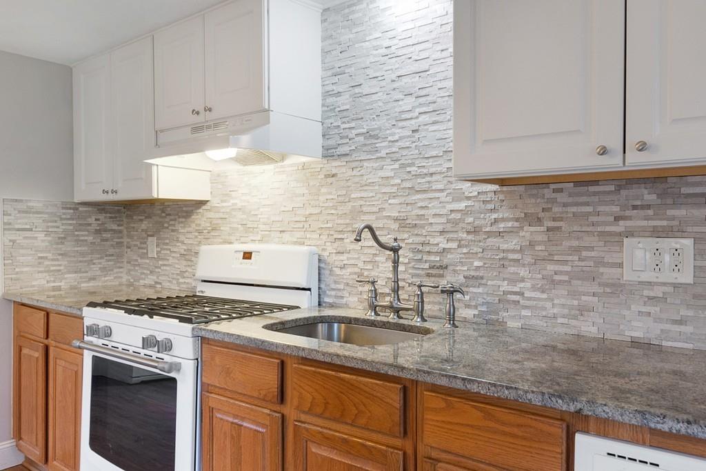 68 Lowell Road Pepperell, MA 01463 - Photo 11 of 24 a kitchen with stainless steel appliances granite countertop a sink stove and cabinets