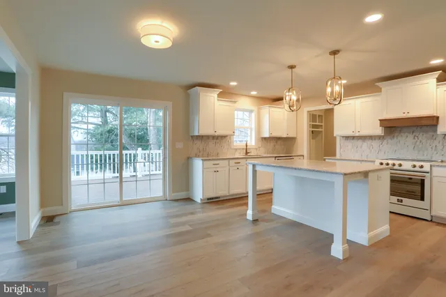a open kitchen with stainless steel appliances granite countertop a stove a sink and a large window