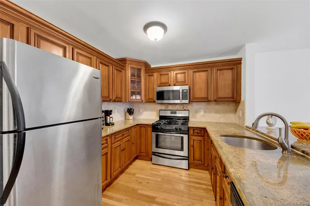 a kitchen with stainless steel appliances granite countertop a refrigerator sink stove microwave and cabinets
