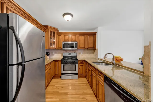 a kitchen with stainless steel appliances granite countertop a refrigerator sink and stove