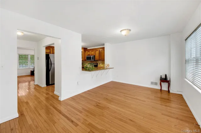 a view of a livingroom with wooden floor and a workspace