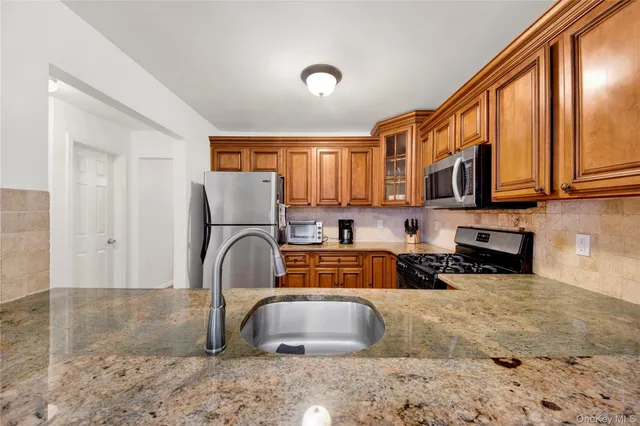 a kitchen with stainless steel appliances granite countertop a stove sink and cabinets