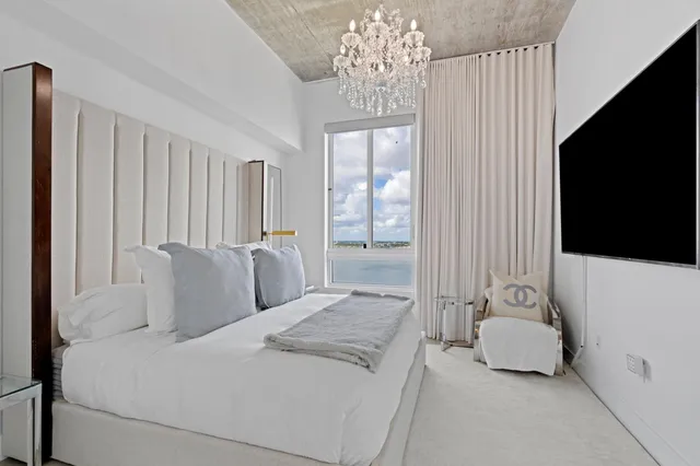 a bedroom with a balcony a bed and a chandelier