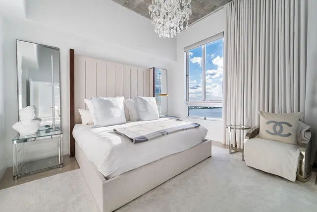 a bedroom with a bed and a chandelier