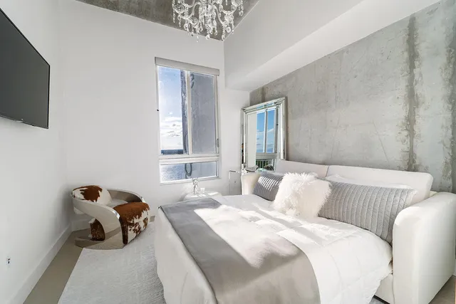 a bedroom with bed and a flat screen tv