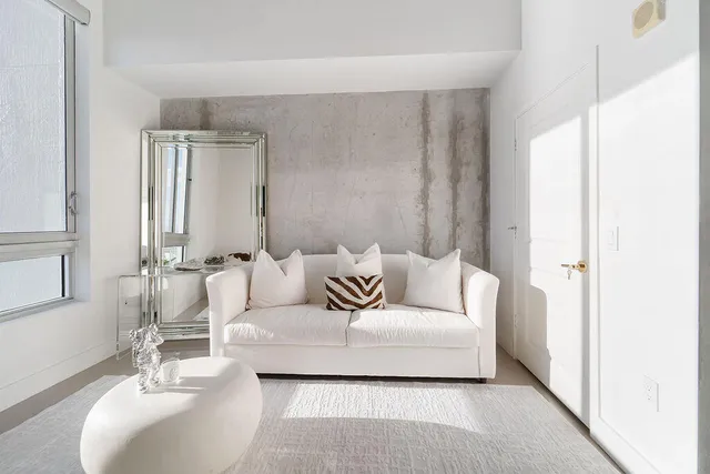 a living room with furniture and a large mirror