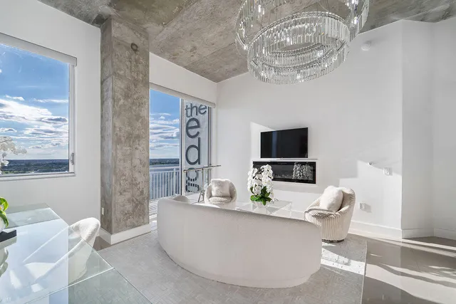 a living room with furniture a chandelier and a flat screen tv