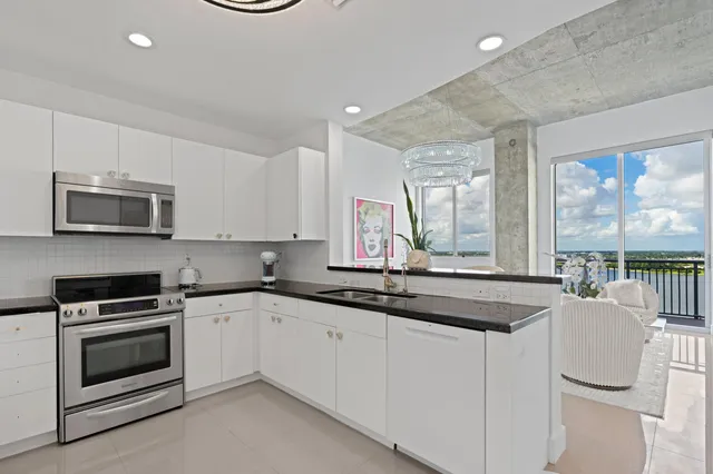 a kitchen with granite countertop a sink and white cabinets