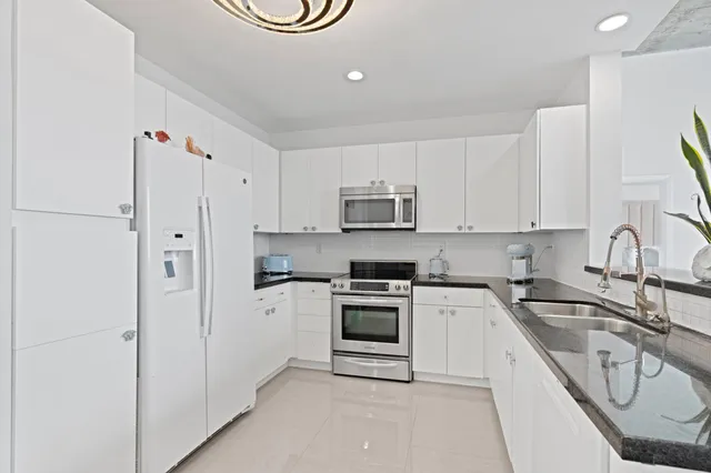 a kitchen with white cabinets and white appliances