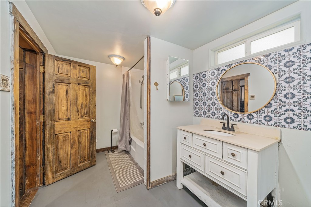 1501 Oriole Road Wrightwood, CA 92397 - Photo 19 of 29 a bathroom with a double vanity sink a mirror and a bathtub