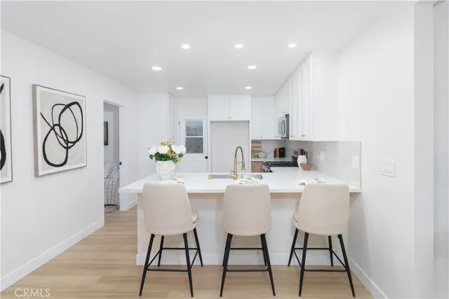 a kitchen with a table chairs refrigerator and microwave