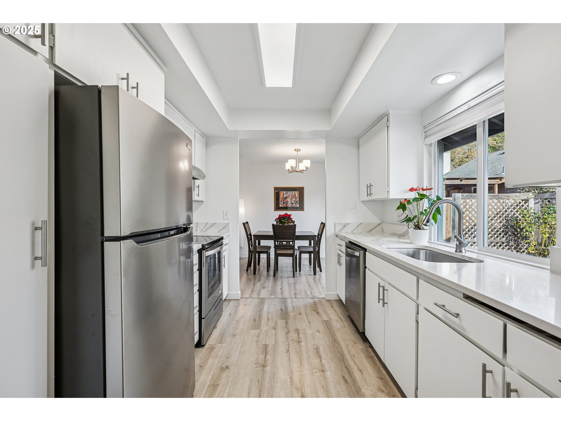 15920 Southwest Century Oak Circle Portland, OR 97224 - Photo 16 of 30 a kitchen with a refrigerator a sink and a dining table