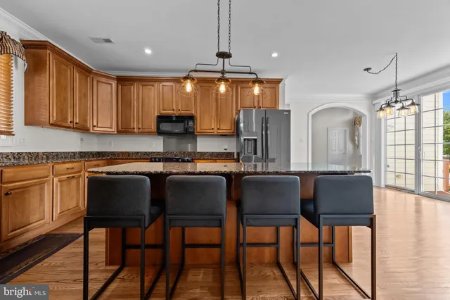a kitchen with granite countertop a table chairs stove and cabinets