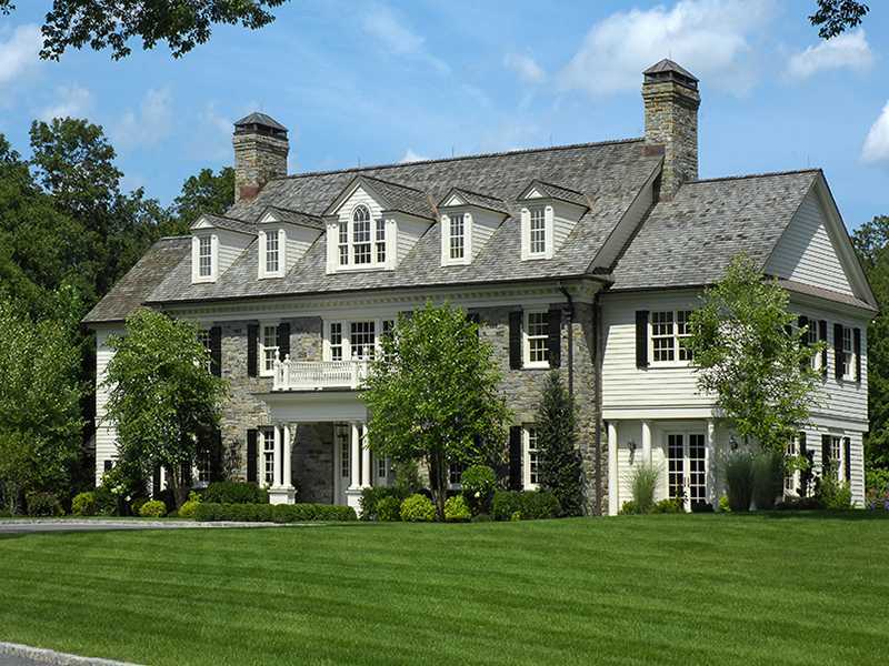 717 Riversville Road Greenwich, CT 06831 - Photo 2 of 24 a front view of a house with a garden