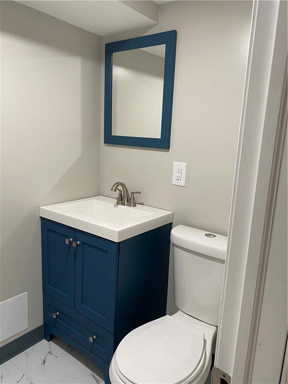 238 Hickory Street McKees Rocks, PA 15136 - Photo 17 of 18 a bathroom with a toilet a sink a vanity and mirror