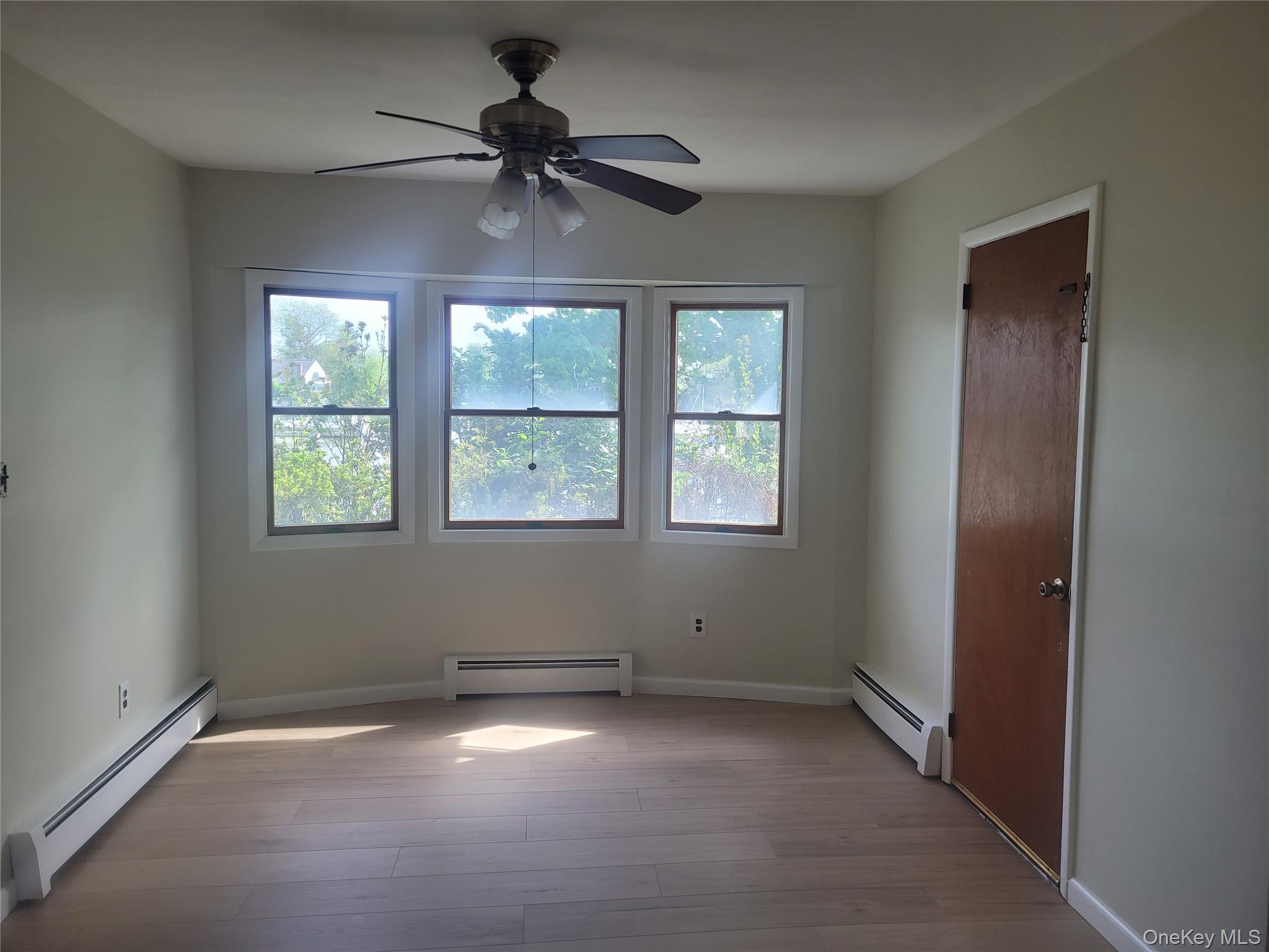 8 Cornell Road East Patchogue, NY 11772 - Photo 6 of 18 an empty room with a window and a fan