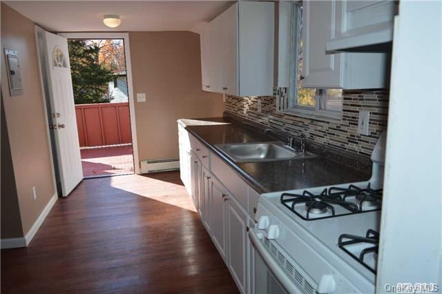62 Wheeler Road, Unit 1NORTH Central Islip, NY 11722 - Photo 1 of 1 a kitchen with a sink stove and cabinets