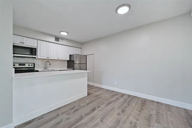 a kitchen with stainless steel appliances a refrigerator sink and microwave