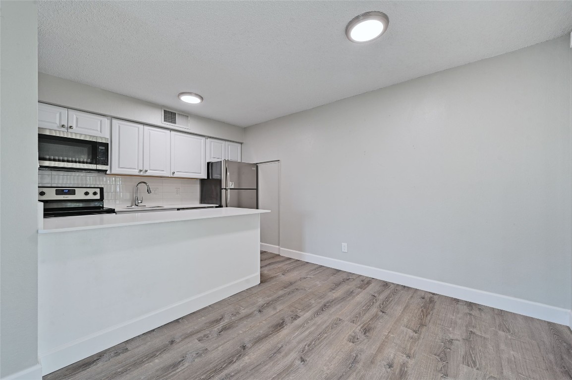 1200 Banister Lane, Unit 2 Austin, TX 78704 - Photo 8 of 14 a kitchen with stainless steel appliances a refrigerator sink and microwave