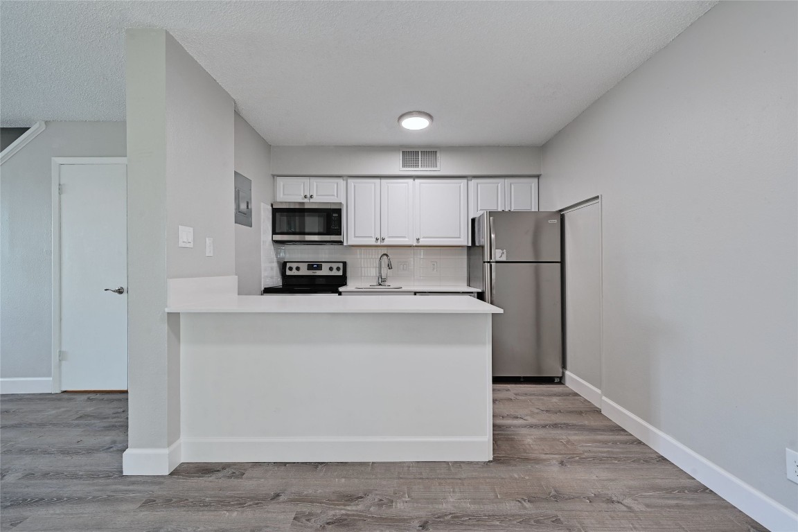 1200 Banister Lane, Unit 2 Austin, TX 78704 - Photo 9 of 14 a kitchen with stainless steel appliances a refrigerator and a stove top oven