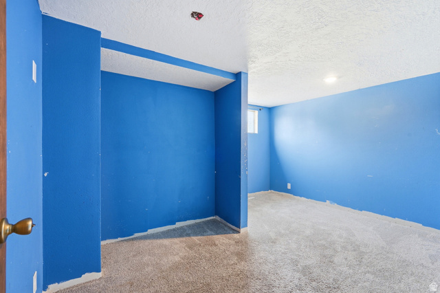 1410 Sumac Drive Logan, UT 84321 - Photo 22 of 28 Carpeted room featuring blue painted walls, a textured white ceiling, and a single window