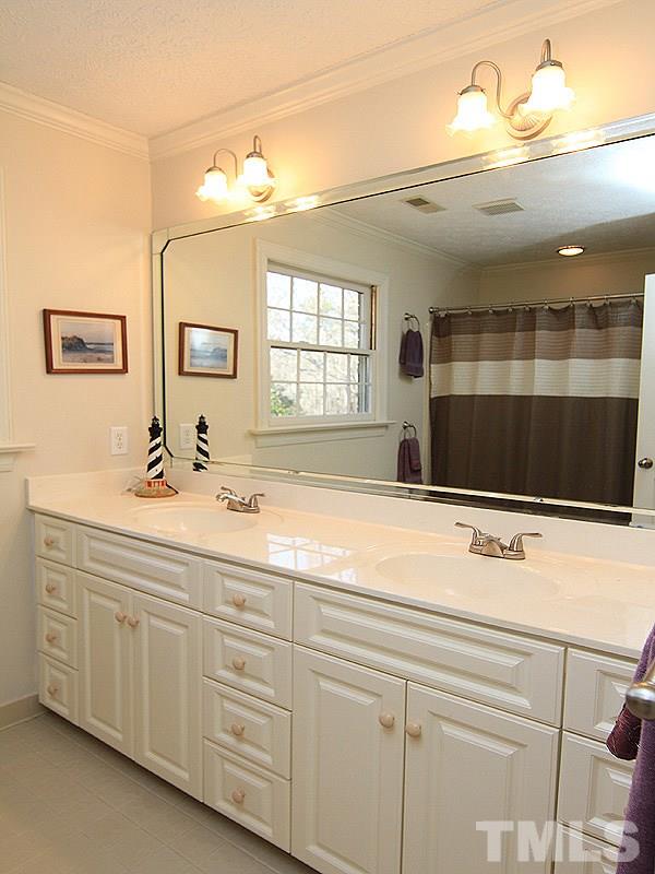 5016 Trail Ridge Drive Raleigh, NC 27613 - Photo 20 of 25 a bathroom with a sink a large mirror and a shower