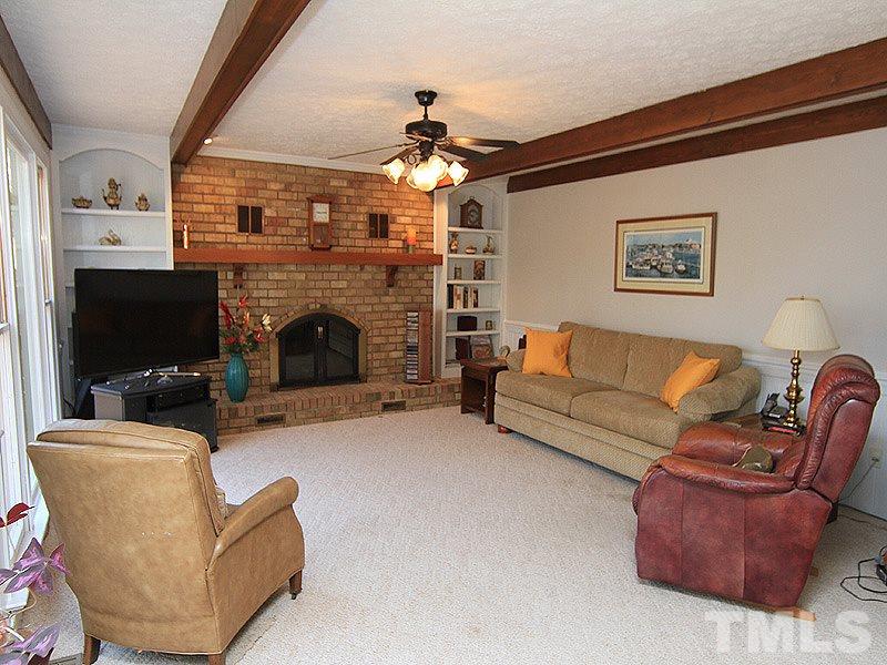 5016 Trail Ridge Drive Raleigh, NC 27613 - Photo 7 of 25 a living room with furniture a flat screen tv and a fireplace