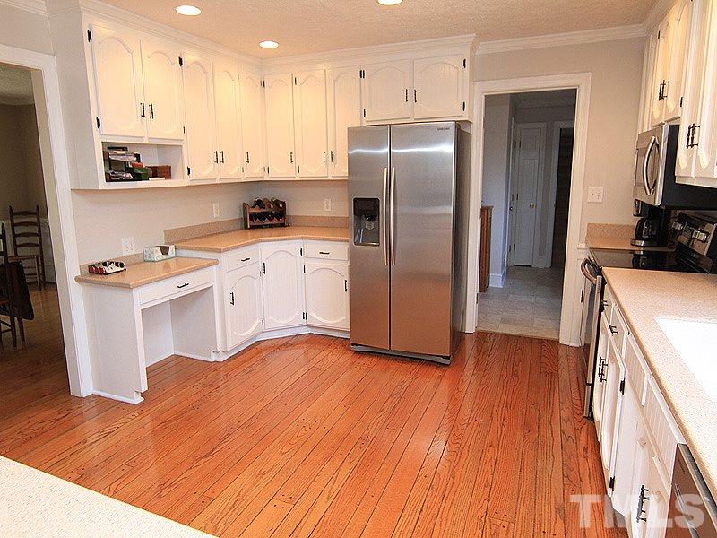 5016 Trail Ridge Drive Raleigh, NC 27613 - Photo 10 of 25 a kitchen with stainless steel appliances granite countertop a refrigerator a stove a sink and white cabinets with wooden floor