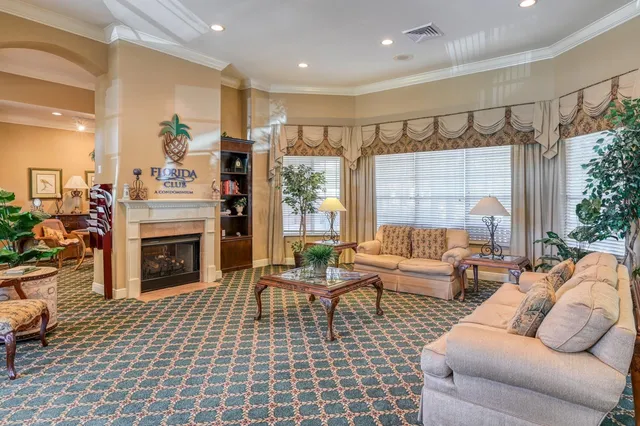 a living room with furniture a fireplace and a chandelier