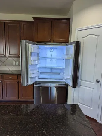 a kitchen with granite countertop white cabinets and stainless steel appliances