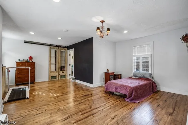 a spacious bedroom with a bed and a flat screen tv