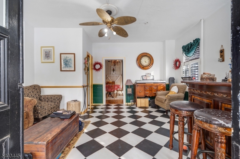 44 Main Street Califon, NJ 07830 - Photo 40 of 43 a living room with a black white checkered floor with couches chair and a stove with wooden floor