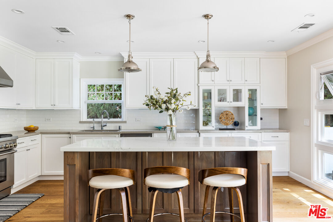 a kitchen with granite countertop white cabinets and a chandelier