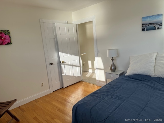 123 Seneca Drive Groton, CT 06340 - Photo 11 of 25 a bedroom with a bed and wooden floor