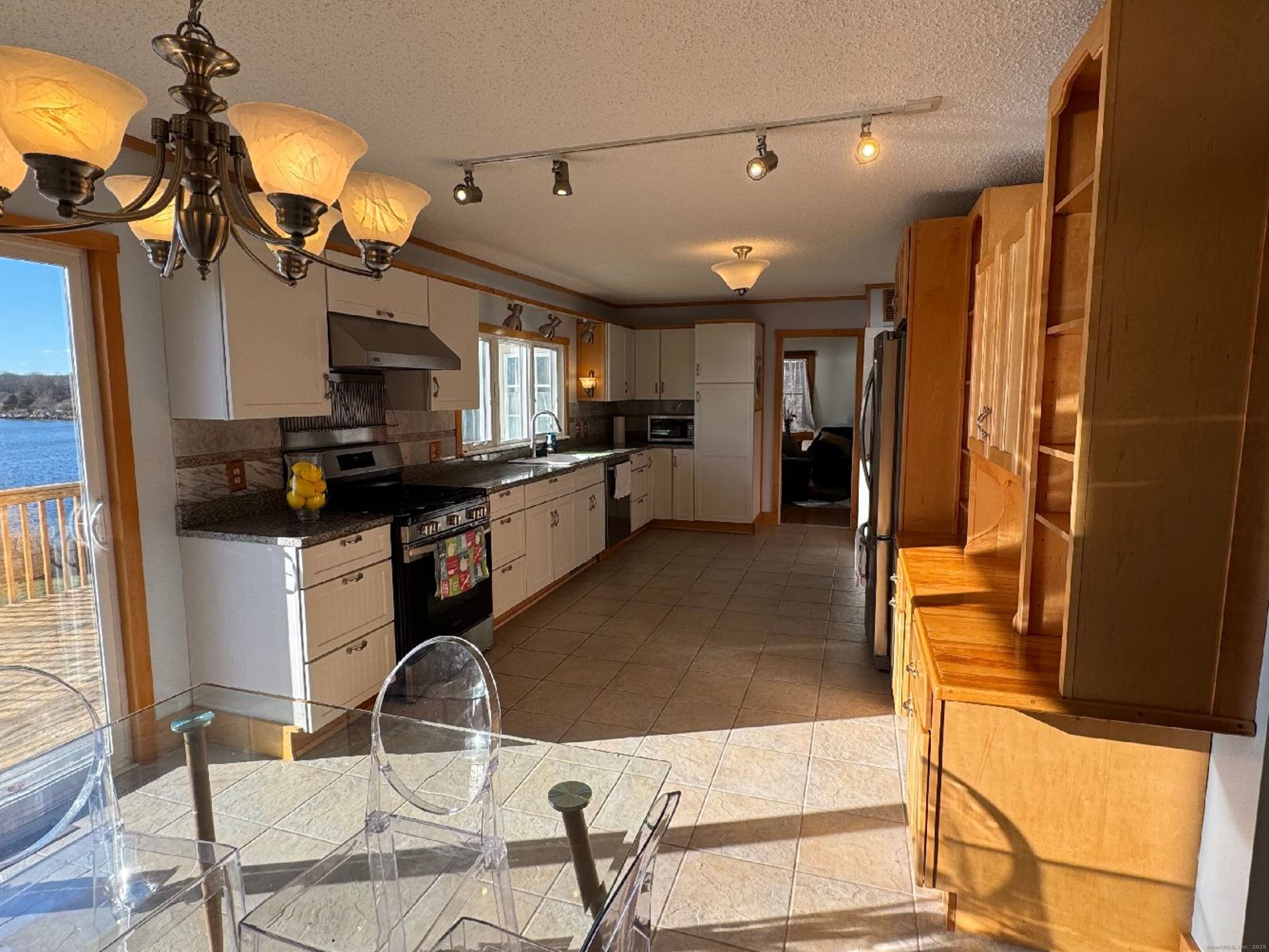 123 Seneca Drive Groton, CT 06340 - Photo 18 of 25 a kitchen with stainless steel appliances kitchen island granite countertop a refrigerator and a stove top oven