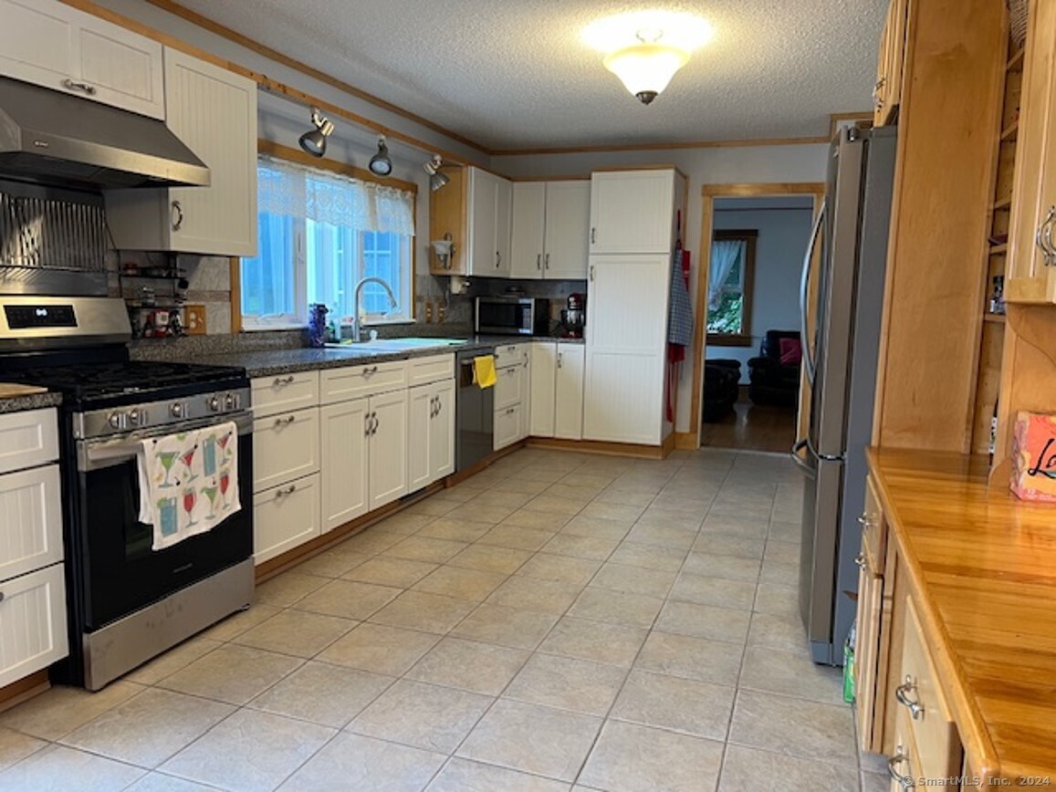 123 Seneca Drive Groton, CT 06340 - Photo 2 of 25 a kitchen with stainless steel appliances granite countertop a stove a sink and a refrigerator