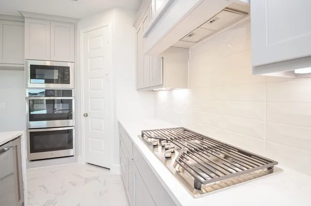 a large white kitchen with a sink a washer and dryer