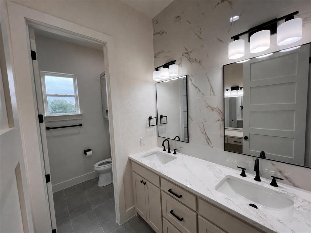 121 Cartwright Park Road Weatherford, TX 76087 - Photo 11 of 17 Double vanity featuring undermount sinks, white countertops, and matte black fixtures