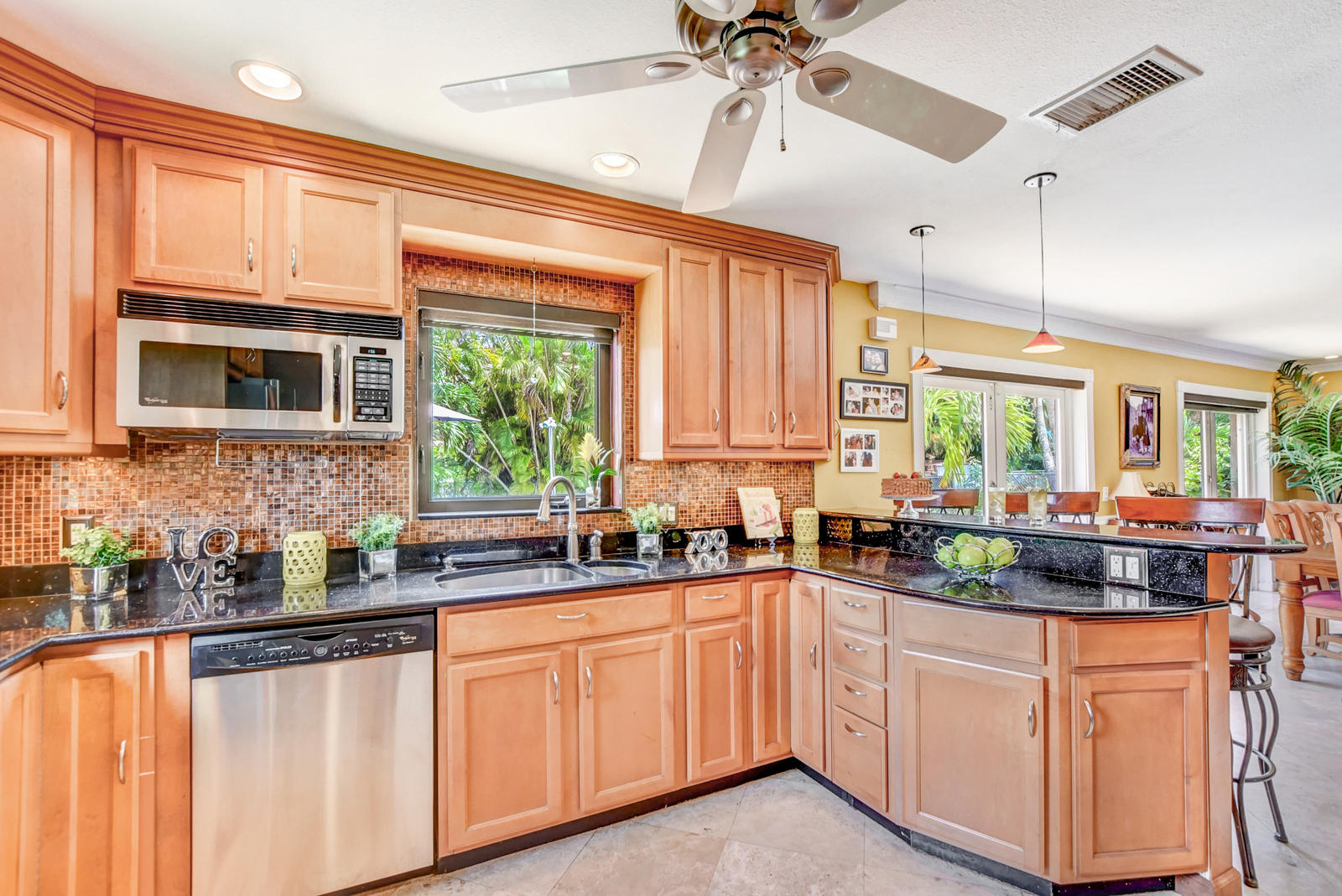 4542 Avalon Street Boca Raton, FL 33428 - Photo 16 of 51 a kitchen with stainless steel appliances a sink a stove a refrigerator cabinets and a window