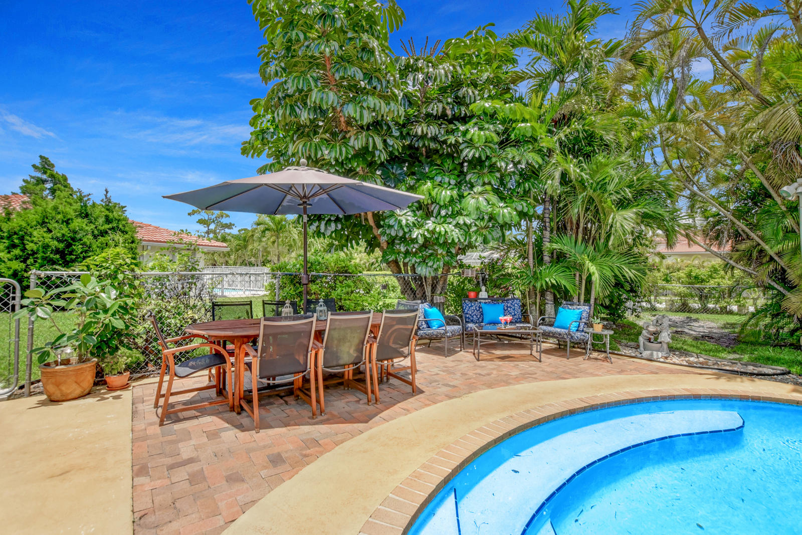 4542 Avalon Street Boca Raton, FL 33428 - Photo 38 of 51 a view of a patio with a table and chairs under an umbrella