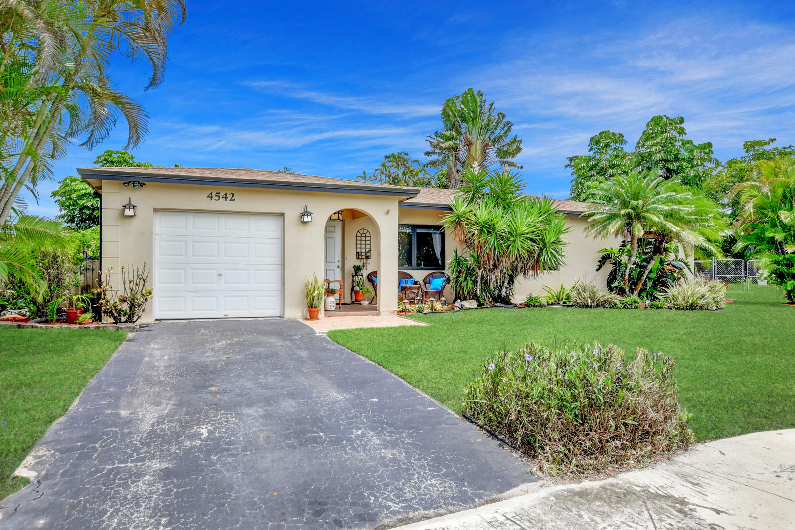 4542 Avalon Street Boca Raton, FL 33428 - Photo 8 of 51 a view of a white house with a small yard and potted plants