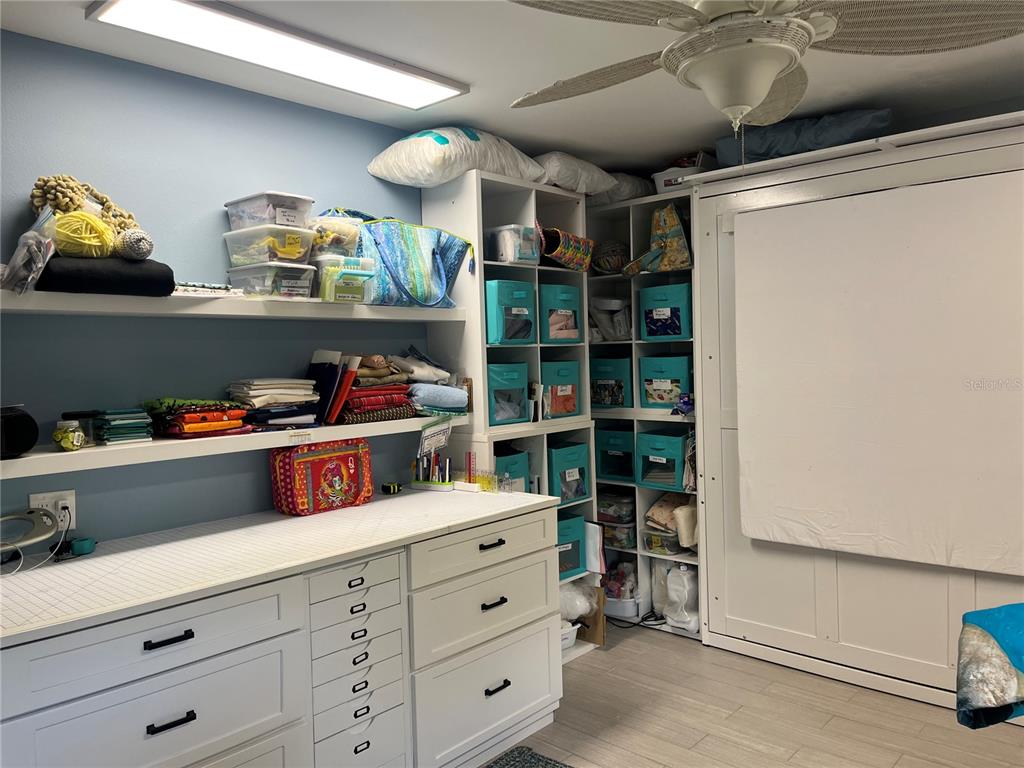 4154 66th St Circle West, Unit 4154 Bradenton, FL 34209 - Photo 15 of 28 a kitchen with lots of clutter and cabinets